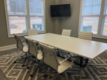A conference room with a large table and chairs.